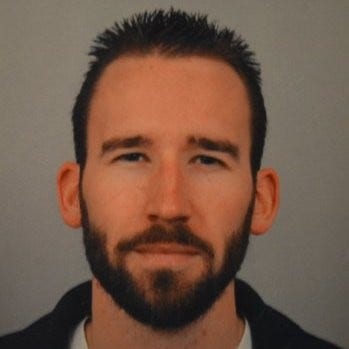 A person with a beard Description automatically generated