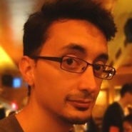 A person wearing glasses and a brown shirt Description automatically generated