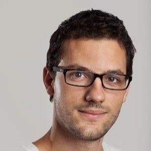 A person wearing glasses and a white shirt Description automatically generated