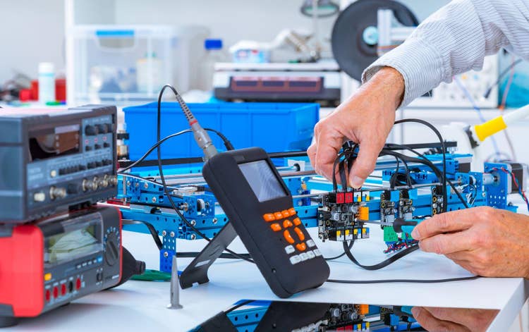 Technician Works on Capacitance Meter in Shop