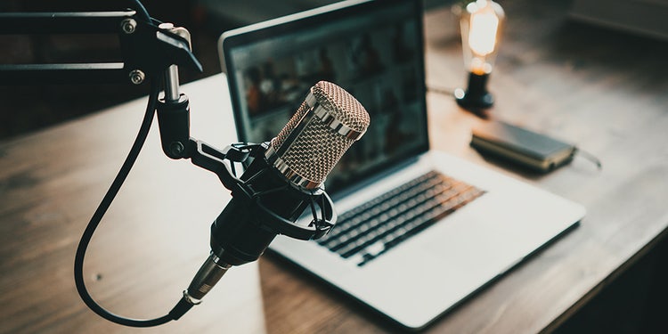 podcast microphone and open laptop