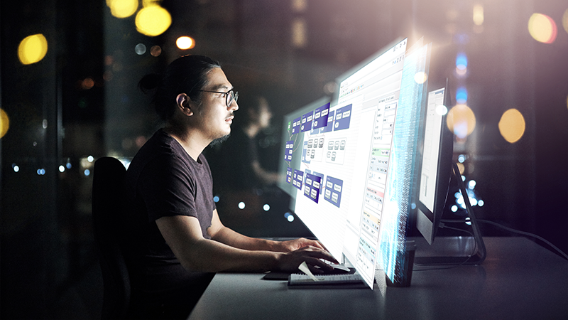 Person working in front of computer with its screen in layers