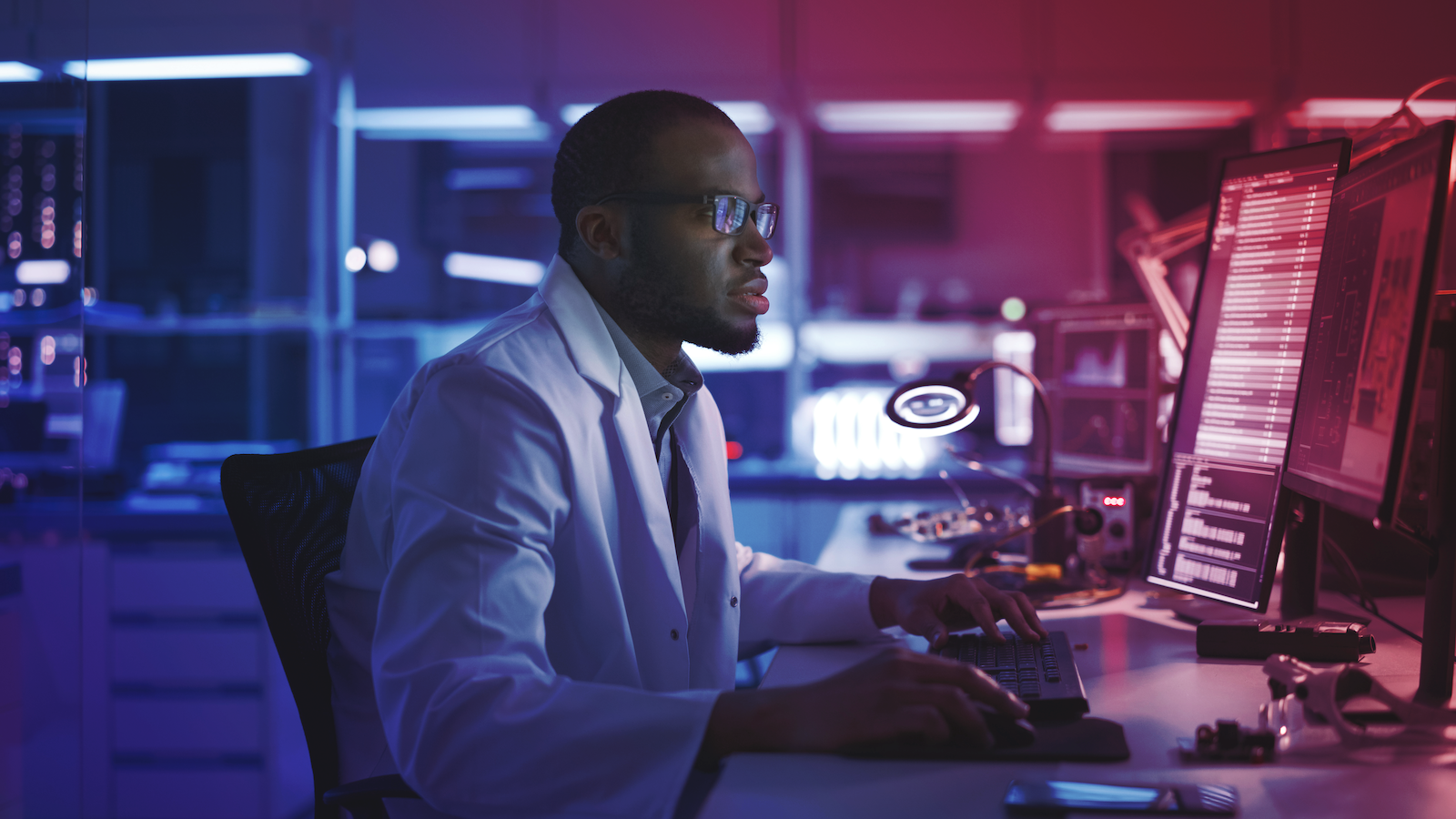 Imaging systems design consultant works on computer in office setting