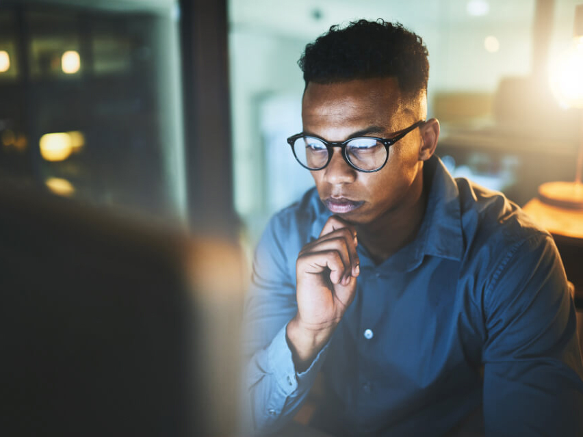 Software engineer works on computer in a dark room