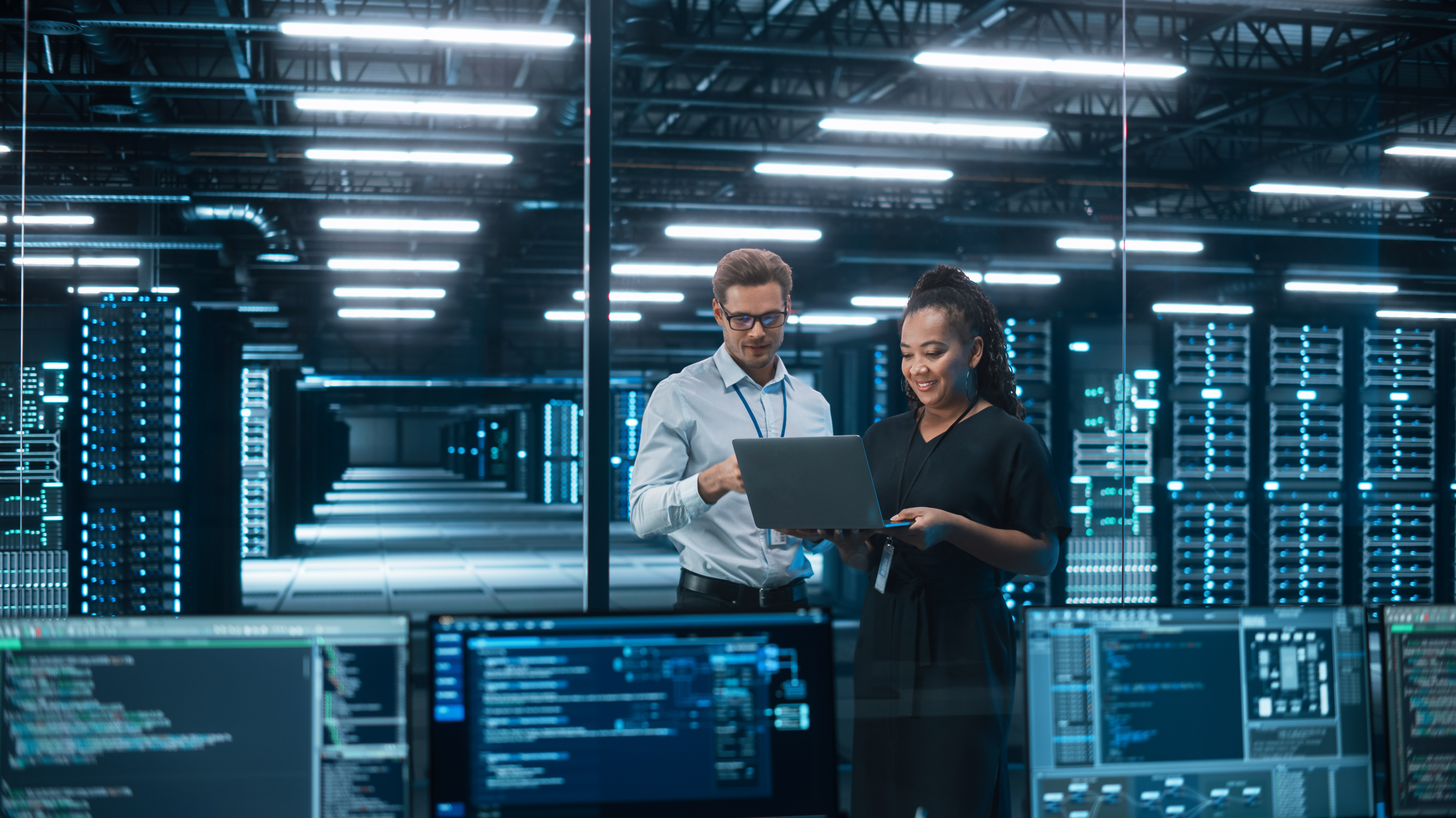Two engineers working together in a data center.