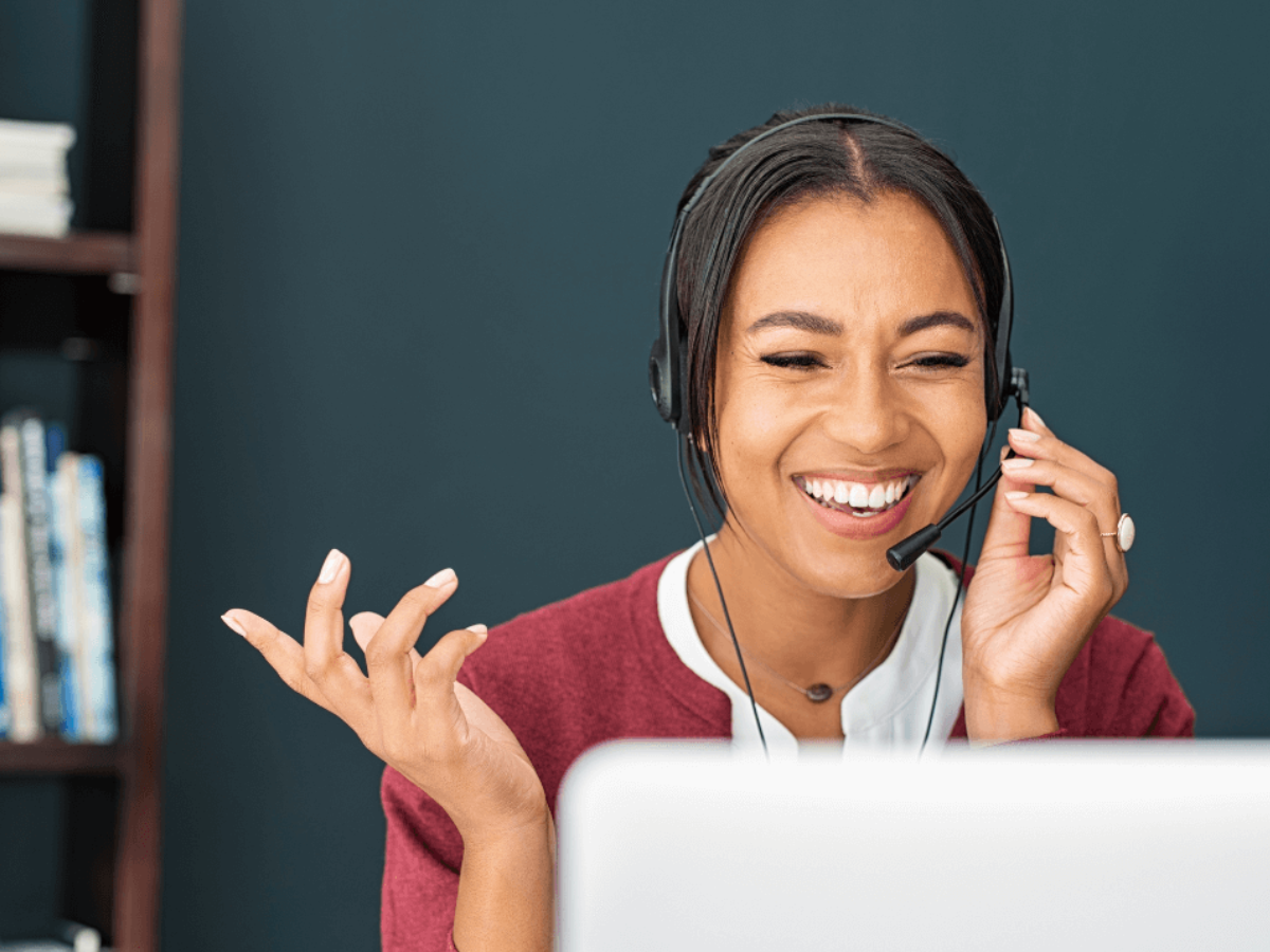 Customer service agent speaks on headset with big smile